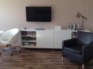 sala de estar con escritorio blanco y TV en la pared en Sunny Apartment en Innsbruck