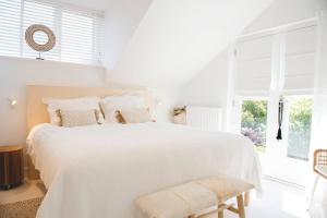Un dormitorio blanco con una cama blanca y una ventana en Luxury villa on peaceful location. Boat optional, en Vinkeveen