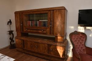 un armario de madera con estante para libros y TV en La Casa del Grillo en Viterbo