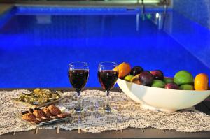 una mesa con dos copas de vino y un tazón de fruta en Bikta Banof, en Rosh Pina