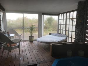 a bedroom with a bed in a room with windows at Chacra La Escondida in Colonia del Sacramento +291 photos