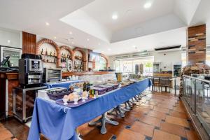 a large kitchen with a blue table with food on it at Residencial Mares in Tavira