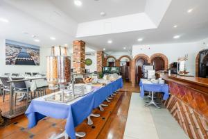 een eetkamer met een lange tafel met blauwe tafels bij Residencial Mares in Tavira