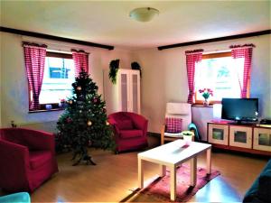 a living room with a christmas tree in a room at Haus Taekema Appartments in Glanegg
