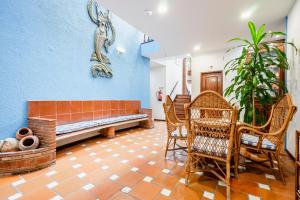 a living room with a bench and a table and chairs at Residencial Mares in Tavira