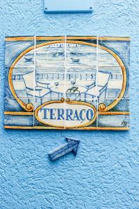 a sign for a tavern on the side of a building at Residencial Mares in Tavira