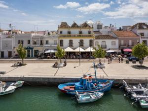 een groep boten aangemeerd in het water in een haven bij Residencial Mares in Tavira
