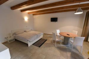 - une chambre avec un lit, une table et des chaises dans l'établissement Agriturismo Kralj, à Trieste