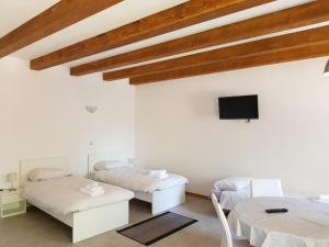 a bedroom with two beds and a tv on the wall at Agriturismo Kralj in Trieste