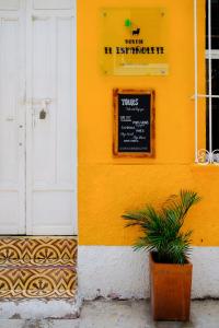 a yellow building with a yellow sign on it at Hostal Españolete in Santa Marta