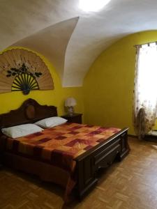 a bedroom with a bed and a yellow wall at Condino in Condino