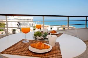 a table with two glasses of orange juice and croissants at Nogalera Terrace by Madflats Collection in Torremolinos