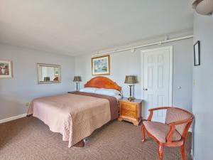 a bedroom with a bed and a chair at Atlantic Sands in Hampton