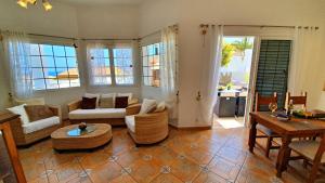 uma sala de estar com um sofá, cadeiras e uma mesa em Ferienhaus Casa Blanca - Tarajalejo - Glasfaserinternet - Meerblick em Tarajalejo