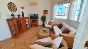uma sala de estar com sofás e uma televisão em Ferienhaus Casa Blanca - Tarajalejo - Glasfaserinternet - Meerblick em Tarajalejo