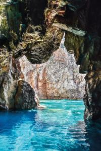 a pool of blue water in a rocky canyon at Bed and Breakfast Porto Flavia in Iglesias