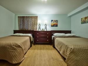 a hotel room with two beds and a dresser at Atlantic Sands in Hampton
