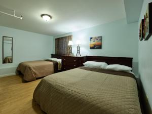 a hotel room with two beds and a mirror at Atlantic Sands in Hampton