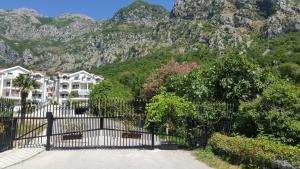 a fence in front of a building with mountains in the background at Roman Gardens Studio Apartment in Risan