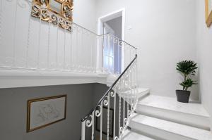 a staircase with white walls and a white stair case at Number 28 - The house with the blue door in Żebbuġ
