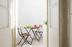 una mesa con 2 sillas y una mesa con fruta. en Number 28 - The house with the blue door, en Żebbuġ