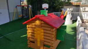a playground with a toy house and a play structure at Roman Gardens Studio Apartment in Risan