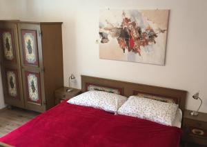 - une chambre avec un lit et une couverture rouge dans l'établissement Appartement Kerschbaumer, à Rangersdorf