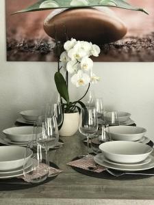施瓦瑙的住宿－Casa Blanca 1，桌子,上面有盘子,玻璃杯,花瓶