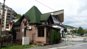 a small house with a green roof on a street at Art in Nova Varoš