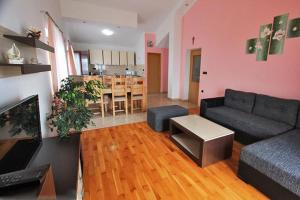 a living room with a couch and a table and a kitchen at Apartmani Ante in Jasenice