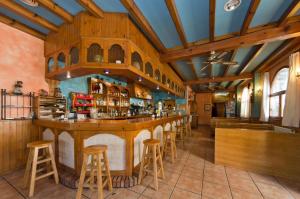 a bar in a restaurant with wooden stools at Apartamentos Casa Aneta in Sarvisé
