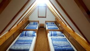a group of four beds in a small room at Natural Cottage Una in Bihać +50 photos