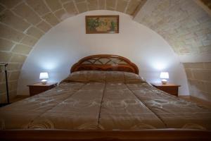 a bedroom with a bed with two lamps on two tables at La Casa di Montegrosso in Matera