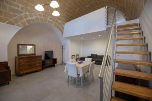 a living room with a staircase and a table and chairs at La Casa di Montegrosso in Matera