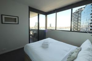 a hotel room with a bed and a large window at ACD Apartments in Melbourne