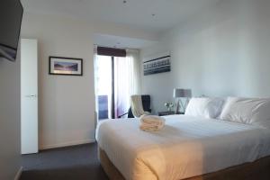 a bedroom with a bed with a stuffed animal on it at ACD Apartments in Melbourne
