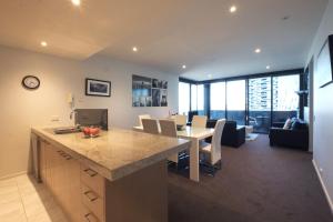 a kitchen and living room with a table and chairs at ACD Apartments in Melbourne