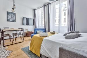 a bedroom with a bed and a table and chairs at Amazing 2 Rooms Flat near Bastille - An Ecoloflat in Paris