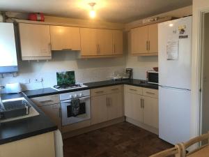 Una cocina con electrodomésticos blancos y un refrigerador blanco. en HOUSE shared, New Build 36 Nottingham 3bedrooms, en Nottingham