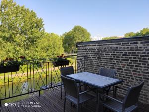 una mesa y sillas en un balcón con una pared de ladrillo en HORTILLON, en Amiens