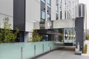 京都Via Inn Prime Kyotoeki Hachijoguchi的酒店与恶棍在建筑物前的标志