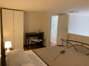 1 dormitorio con 1 cama con tocador y escritorio en Melito 30 - Raiola Welcome, en Torre Annunziata