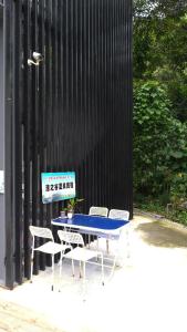 埔里鎮的住宿－漾之谷溫泉民宿 ，黑色墙壁前的一张蓝色桌子和椅子