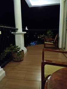 a patio area with chairs, tables, and a balcony at 36 Bed & Breakfast in Kandy