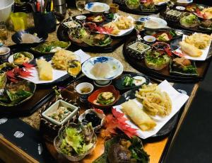 古民家の宿 ふるま家 Furumaya House Gastronomic Farmstay in Deep Kyoto في فوكوتشياما: طاولة عليها العديد من أطباق الطعام