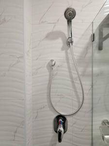 a shower with a hose attached to a glass door at M Design Hotel @ Taman Pertama in Kuala Lumpur