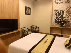 a hotel room with two beds and a flat screen tv at Bideco Hotel in Thu Dau Mot