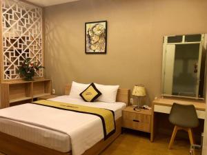 a bedroom with a bed and a desk with a chair at Bideco Hotel in Thu Dau Mot
