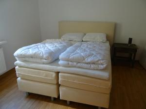 a bed with white sheets and pillows on it at Haus Moezelblik in Zell an der Mosel