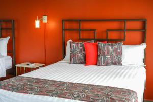 a bedroom with a bed with an orange wall at Campos Arenal Hotel in Fortuna +32 photos